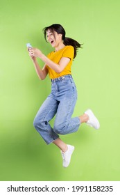Full body portrait of young asian girl on green background
 - Shutterstock ID 1991158235