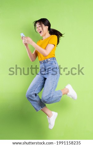 Full body portrait of young asian girl on green background
