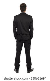Full body portrait of young businessman, back view, with hands in pocket isolated over white background 