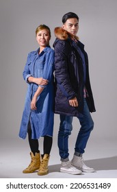 Full Body Portrait Of A 
Young Couple In Fur Coat ,jeans Dress Standing Together Posing In Studio 
