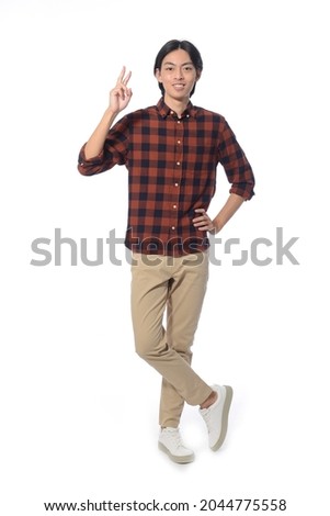 Full body portrait of young man with khaki, showing two finger in studio isolated on white background

