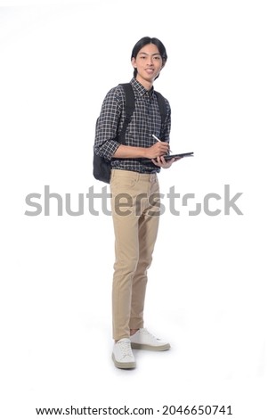 Full body portrait of young man with khaki, with backpack using digital tablet in studio isolated on white background

