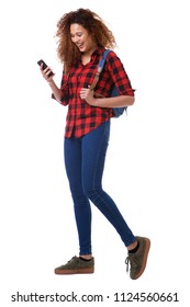 Full Body Portrait Of Young Woman Walking On White Background With Cellphone And Bag