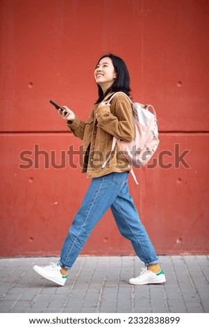 Full body portrait young woman walking bag and phone