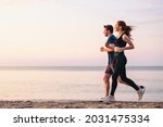 Full body profile couple young two friends strong sporty sportswoman sportsman woman man 20s in sport clothes warm up training run on sand sea ocean beach outdoor jog on seaside in summer day morning
