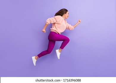 Full Body Profile Photo Of Active Cheerful Lady Jumping High Rushing Speed Finish Line Race Competition Wear Casual Warm Fluffy Sweater Pants Shoes Isolated Purple Color Background