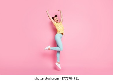 Full Body Profile Photo Of Attractive Lady Two Buns Hold Arms Up Jumping High Rejoicing Carefree Good Mood Wear Casual Striped T-shirt Pants Shoes Isolated Pink Color Background