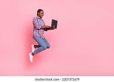 Full body profile photo of attractive energetic lady jump hold netbook empty space isolated on pink color background - Shutterstock ID 2207371679