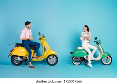 Full body profile photo of funny lady guy two people driving two vintage moped together browsing telephone affectionate feelings formalwear outfit isolated blue color background
