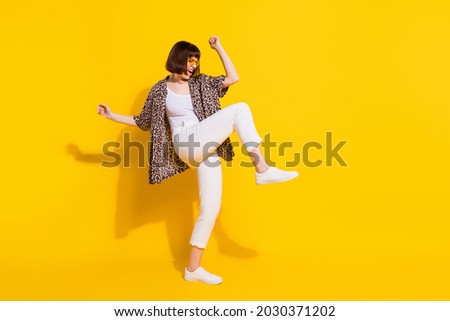 Full body profile photo of funny millennial lady dance wear eyewear shirt trousers sneakers isolated on yellow color background