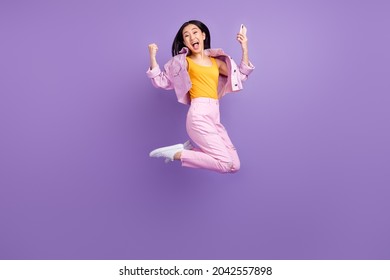 Full body profile photo of hooray millennial brunette lady jump wear jacket jeans sneakers isolated on violet background