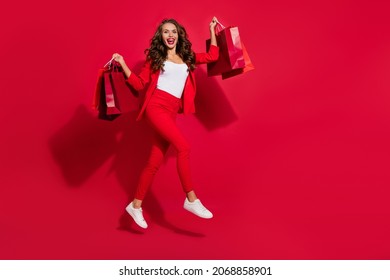 Full body profile photo of impressed nice brunette lady run do shopping wear suit shoes isolated on red color background - Powered by Shutterstock