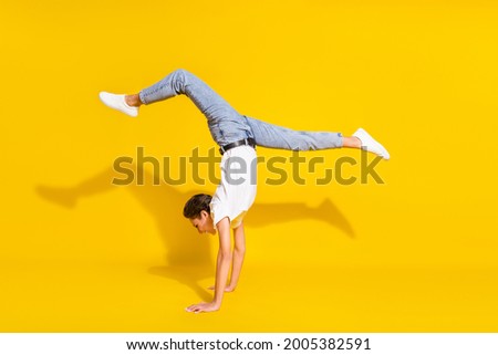 Similar – Man practicing yoga, handstand against a yellow wall