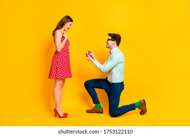 Full body profile photo of pretty lady handsome guy couple proposing girlfriend stand one knee hold diamond ring box wear red dress shirt bowtie isolated yellow bright color background - Powered by Shutterstock