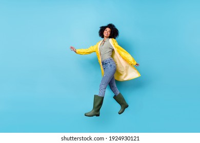 Full body profile photo of pretty energetic dark skin lady running look camera isolated on blue color background - Shutterstock ID 1924930121