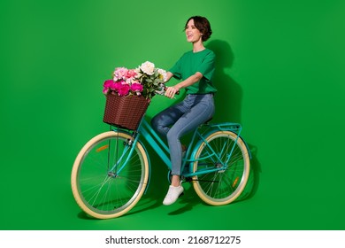 Full body profile photo of stunning cheerful lady ride bike look empty space isolated on green color background