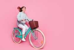 Full Body Profile Side Photo Of Young Girl Look Empty Space Enjoy Ride Bike Isolated Over Pink Color Background