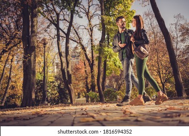 Full Body Profile Side Photo Of Positive Couple Go In Autumn September Town Center Park Path Speak Wear Jacket Rucksack