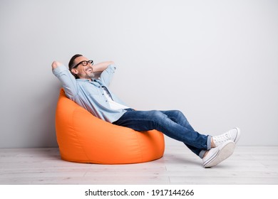 Full body profile side photo of man happy positive smile sit bag rest relax look empty space isolated over grey color background - Powered by Shutterstock