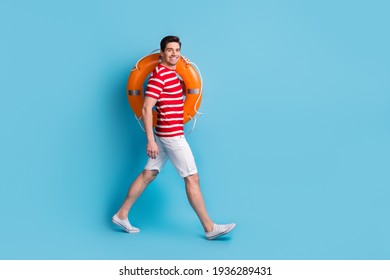 Full Body Profile Side Photo Of Happy Man Hold Orange Lifesaver Ring Go Copyspace Isolated On Blue Color Background