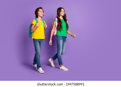 Full body profile side photo of two cheerful kids happy positive smile go walk school carry bags isolated over violet color background