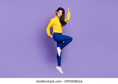 Full Body Profile Side Photo Of Triumphant Young Woman Raise Fists Win Jump Up Air Isolated On Violet Color Background