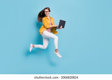 Full Body Profile Side Photo Of Young Woman Happy Positive Smile Jump Up Go Run Hold Laptop Isolated Over Blue Color Background