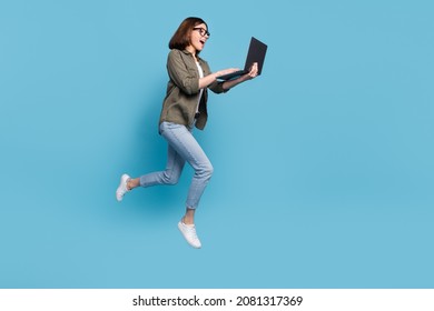 Full body profile side photo of computer nerd lady jump use device chatting wear shirt denim jeans isolated over blue color background - Shutterstock ID 2081317369