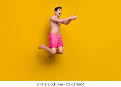 Full body profile side photo of young man happy positive smile jump swim ocean vacation isolated over yellow color background - Powered by Shutterstock