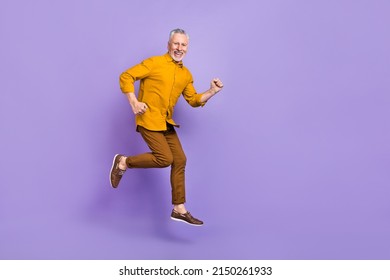 Full Body Profile Side Photo Of Senior Man Runner Jumper Rush Motion Isolated Over Purple Color Background