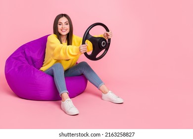 Full Body Profile Side Photo Of Young Girl Sit Violet Beanbag Ride Auto Race Weekend Isolated Over Pink Color Background