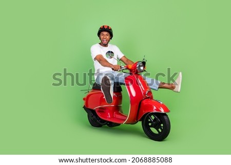 Full body profile side photo of young african man drive motor bike vehicle isolated over green color background