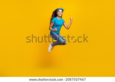 Full body profile side photo of young excited girl jump rejoice victory fists hands awesome isolated over yellow color background