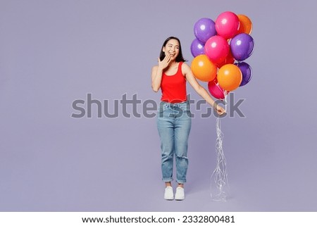 Full body satisfied young woman of Asian ethnicity she wear casual clothes red tank shirt hold bunch of colorful air balloons isolated on plain pastel light purple background studio. Lifestyle concept