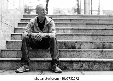 Full Body Shot Of Bald Senior Man Thinking While Sitting On The Staircase In Bangkok Thailand