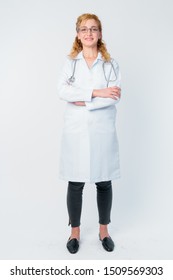 Full body shot of happy blonde woman doctor smiling with arms crossed