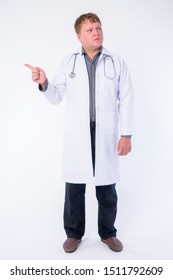 Full body shot of overweight man doctor pointing finger and looking away