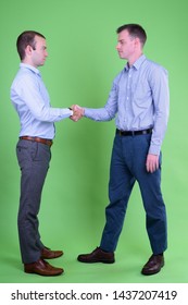 Full Body Shot Of Two Businessmen Shaking Hands Together