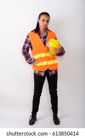 Full Body Shot Of Young Asian Woman Construction Worker Standing While Holding Hard Hat Against White Background