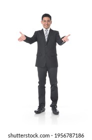 Full Body Shot Of Young Handsome Businessman In Suit  Showing Both Hands Open Palms
Posing In Studio
