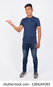 Full Body Shot Of Young Happy Asian Man Showing Something