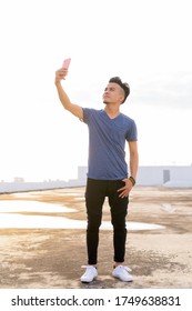 Full Body Shot Of Young Multi Ethnic Man Taking Selfie At Rooftop Of The Building