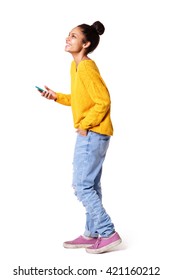 Full Body Side Portrait Of African American Girl Standing With Cell Phone On White Background