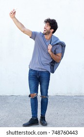 Full Body Side Portrait Of Expressive Happy Man Taking Selfie With Mobile Phone