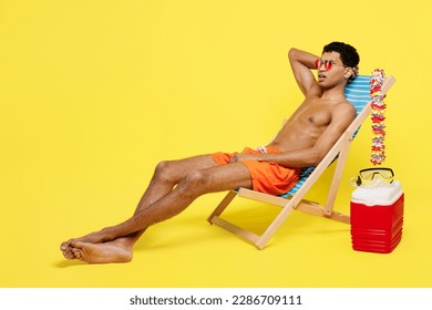 Full body side profile view shocked young sexy man wearing orange shorts swimsuit relax near hotel pool sit in deckchair isolated on plain yellow background. Summer vacation sea rest sun tan concept - Shutterstock ID 2286709111
