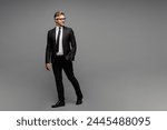 Full body side view adult successful employee business man corporate lawyer wear classic formal black suit shirt tie work in office look aside on area isolated on plain grey background studio portrait