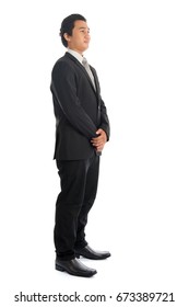 Full Body Side View Of Handsome Young Southeast Asian Businessman Standing Isolated On White Background. 