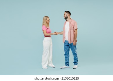 Full Body Side View Happy Young Couple Two Friends Family Man Woman In Casual Clothes Hold Hands Folded Handshake Gesture Together Isolated On Pastel Plain Light Blue Color Background Studio Portrait