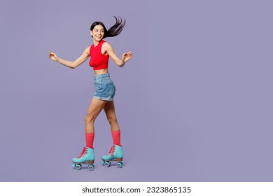 Full body side view happy cheerful active cool young latin woman she wear red casual clothes rollers rollerblading isolated on plain pastel purple background. Summer sport lifestyle leisure concept