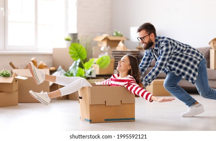 Full body side view of positive family couple young man pushing carton box with laughing woman while having fun together during unpacking things in new home - Powered by Shutterstock